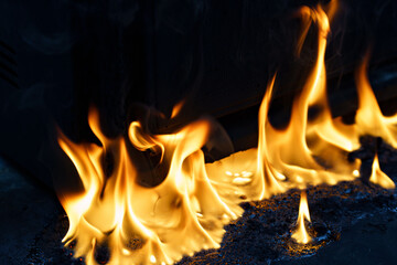 fire and molten plastic on a black background. the concept of fire in the kitchen and malfunctions,...