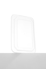 Close-up set of a transparent package for stainless steel cooling cubes for drinks and tongs. The box is isolated on a white-gray background. Front view.