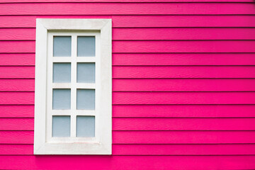 old white window frame on pink decorative wooden wall panel with copy space, selective focus on the window