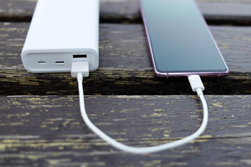 phone is charging from the power bank. The concept of electrical autonomy of gadgets
