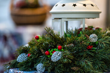 festive decoration with fir branch, ornaments and lantern on christmas market table