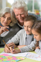 Portrait of grandparents and grandchildren drawing at home