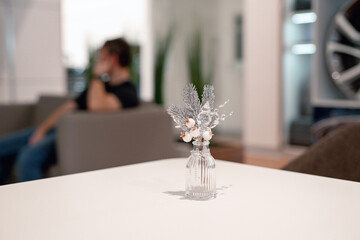 Christmas decoration of a modern office. New Year's installation in the business center. Silver Christmas toys and tinsel. Festive mood in the workplace.  Man unfocused waiting in lobby