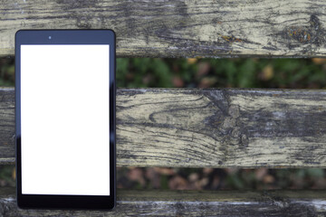 Tablet on a wooden bench. blank screen for design, copy space