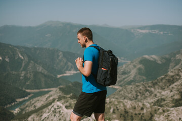 Man with bag at the top of the mountain