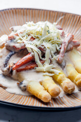 white aparagus with sauce of mushrooms and ham served with blue cheese