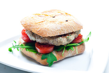 homemade turkey burger with cherry tomatoes and arugula in ciabatta