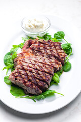 beef steak with garlic dip and spinach and ruccola leaves