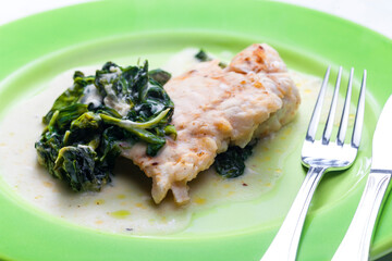 poultry breast with spinach leaves and sauce