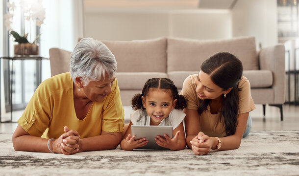 Tablet, children and family with a girl, mother and grandmother streaming or watching movies online together. Kids, internet and love with a woman, parent and daughter bonding while lying on a floor