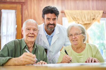 Altenpfleger hilft Senioren Paar beim Rätsel lösen