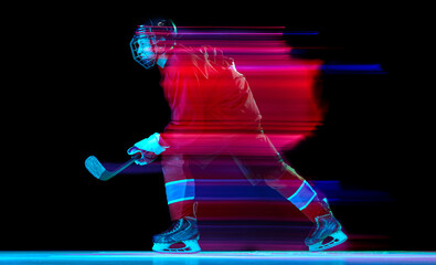 Powerful throw. Male ice hockey player in sports protective uniform in action over dark background...