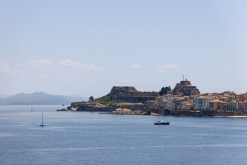 Naklejka premium Little sail and motor boats on the sea ripple in the port of Corfu city against the backdrop of Old Fortress, Kerkira, Ionian islands