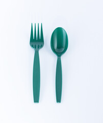 Disposable green plastic cutlery, spoon and fork.