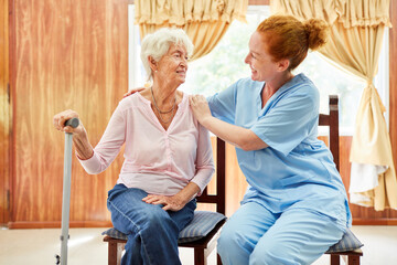 Altenpflegerin kümmert sich um Seniorin mit Krückstock
