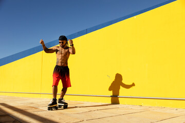 Black man on roller skates riding outside on urban street. Modern man posing on roller skates.