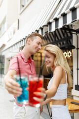 Soft focus young couple outdoor bar ,drinking cocktails or lemonade
