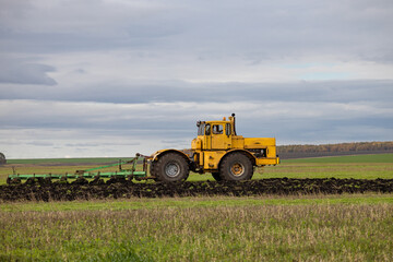 Fototapeta premium old model tractor working in the field.