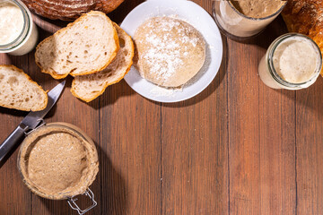 Fototapeta na wymiar Healthy lifestyle, gluten free fermenting diet. Homemade sourdough. Active bubbly rye, wheat, oat sourdough with different flour and fermentation methods, in glass jars, with raw dough and baked bread