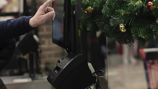 Buyer uses touch panel at self-service checkout ACO. Customer manually enters product name or barcode number. Assisted checkout SCO with cashless payment. Shopping at mall and store. Self-checkout