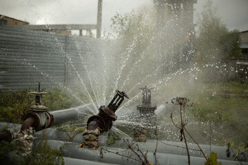 Water pouring out of broken pipe. Pipeline breakthrough. Boiler station accident.