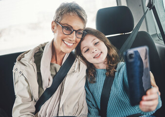Grandmother, girl and selfie with phone in a car while on a road trip for social media post online. Senior woman and kid smile, photo and happy with travel holiday with 5g smartphone in Germany