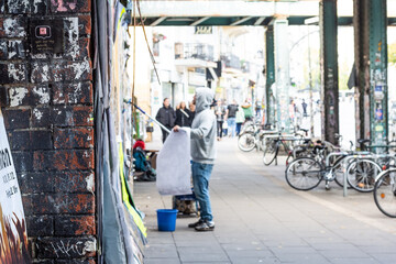 Streetfotografie:  Plakatierer vor überfüllter Plaktatwand