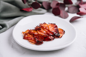 Plate with tasty bacon slices on stone