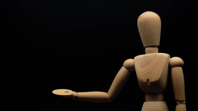 wood mannequin raises right hand at two levels.