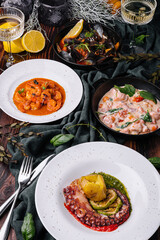 Fototapeta na wymiar Octopus Sicilian, Salmon in cream sauce, Shrimp in Romesco sauce and Mussels