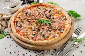 Tasty pizza with ham, mushrooms and onion on the concrete background