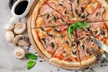 Tasty pizza with ham, mushrooms and onion on the concrete background