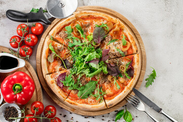 Fresh pizza with meat and vegetables on the concrete background