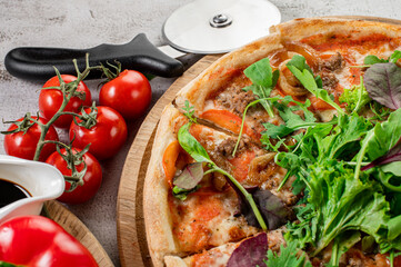 Fresh pizza with meat and vegetables on the concrete background