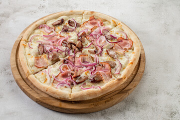 Tasty pizza with ham, mushrooms and onion on the concrete background