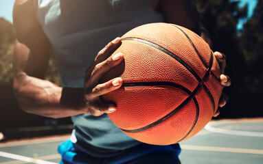 Basketball, basketball player and athlete hands closeup holding ball on basketball court in urban...