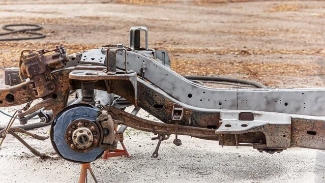 Close up shot of a male woker in a protective clothing and hard hat removing rust from metal through sandblasting in timelapse at daytime.