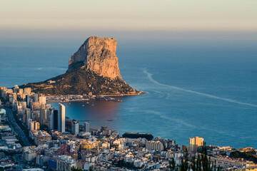 top view of the city of Calpe, the rocks of Ifach and the sea in the evening at sunset