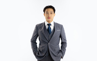 Asian smart businessman in grey suit white shirt blue tie stading and looking camera in front white...
