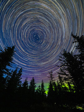 Long exposure astrophotography showing the stars and the northern lights in Denali National Park