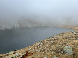 Mystical autumn ambience on the alpine lake Lago d'Orsino in the mountainous area of the St....