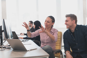 Collaborative process of multicultural skilled young business team during brainstorming meeting in office.Diverse group of young people dressed in formal wear cooperating on developing design project