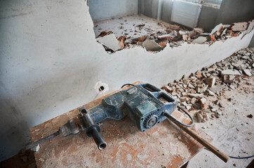 Wooden desk with electric hammer drill for construction and demolition works. Professional tool for...