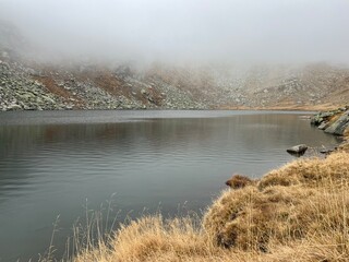 Mystical autumn ambience on the alpine lake Lago d'Orsino in the mountainous area of the St. Gotthard Pass (Gotthardpass), Airolo - Canton of Ticino (Tessin), Switzerland (Schweiz)