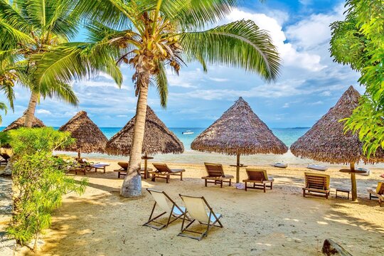 Beach umbrellas and deck chairs by the sea at Nosy Be island, Nosy Komba, North West Madagascar, Indian Ocean