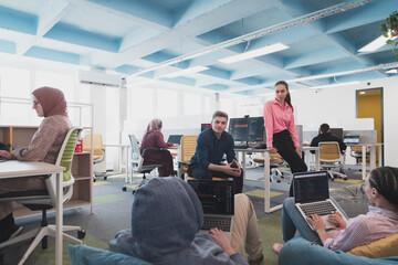 Portrait of young smiling business woman in creative open space coworking startup office. Successful businesswoman standing in office with copyspace. Coworkers working in background.