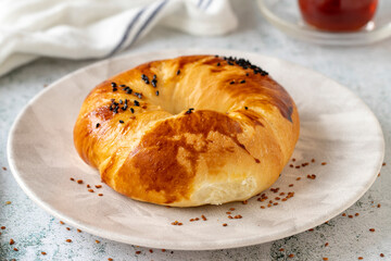 Turkish bagel pogaca with nigella seeds. Traditional flavors. Pogaca on gray background. close up