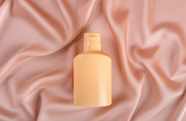 Bottle cosmetic product on pastel textile background. Beauty product concept. Top view
