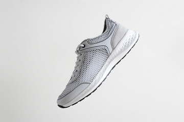 New stylish sneaker for everyday lifestyle levitating in air on light background, side view