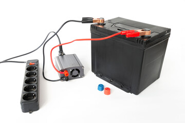 Power inverter connected to a car battery and surge protector, 12v DC to AC converter 220v, on isolated white
